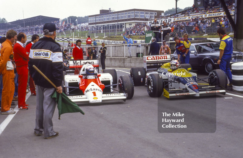 Alain Prost, McLaren MP4, and Nigel Mansell, Williams Honda FW11, wait at the end of the pit lane to get on to the track, Brands Hatch, 1986 British Grand Prix.
