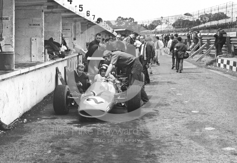 The McLaren Ford M7A of Bruce McLaren receives attention during practice for the 1968 British Grand Prix at Brands Hatch.
