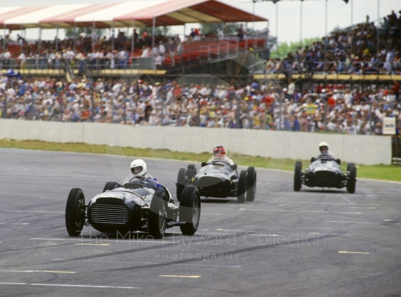 A trio of V16 BRMs howl through Woodcote during a demonstration, British Grand Prix, Silverstone, 1987
