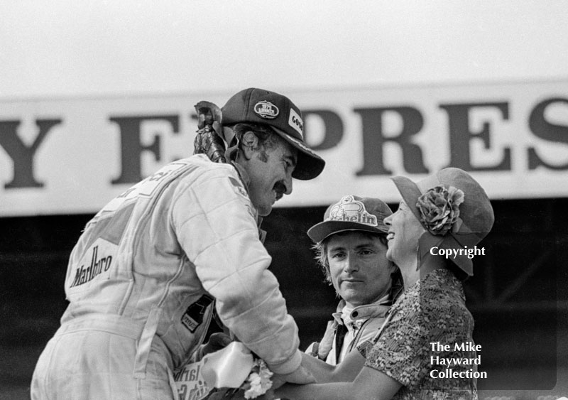 CLay Regazzoni, Williams, and Rene Arnoux, Renault, on the podium after the 1979 British Grand Prix, Silverstone.
