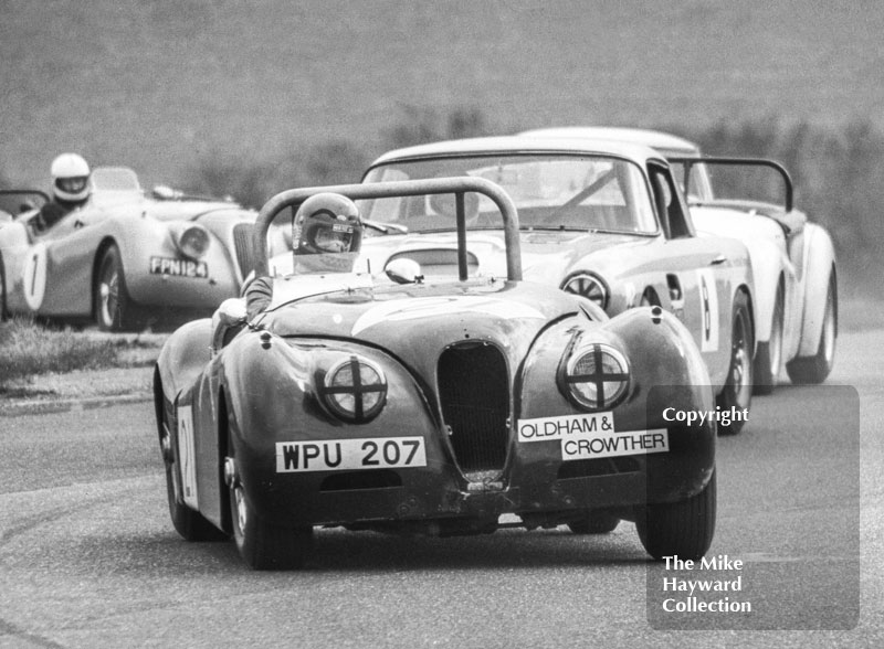 David Preece, Jaguar XK120 (WPU 207), followed by Sylvia Rouse, Aston Martin DB4 and John May (7) Jaguar XK120 (FPN 124)&nbsp;Philips Car Radio Thoroughbred Sports Car race, F2 International meeting, Thruxton, 1977.
