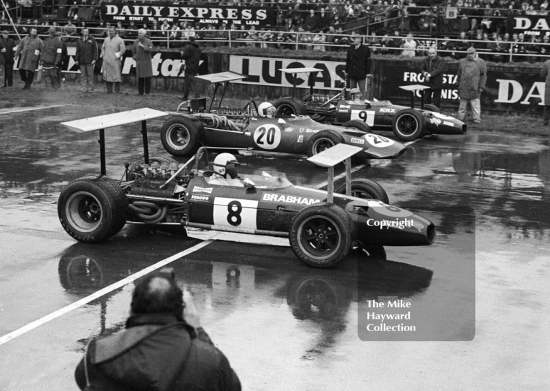 Jack Brabham, Brabham BT26A, leaves the streaming wet starting grid with Chris Amon, Ferrari 312 V1' and Jacky Ickx, Brabham BT26A, Silverstone, International Trophy 1969.
