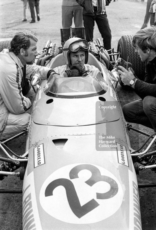 Bruce McLaren and Jo Bonnier try to sort out problems with the Swedish driver's McLaren M5A BRM during practice for the 1968 British Grand Prix at Brands Hatch
