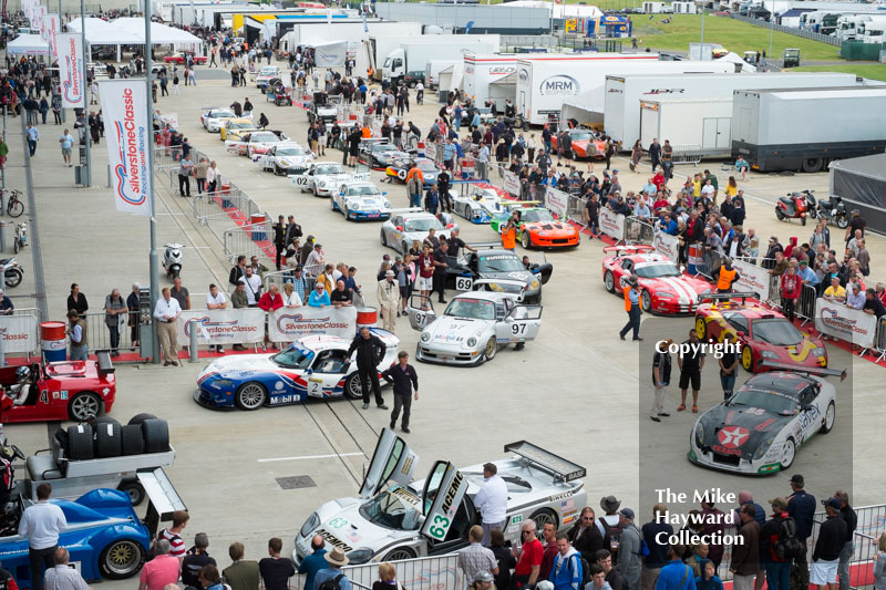 Sports cars lined up in the paddock at the 2016 Silverstone Classic.
