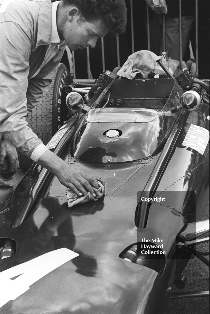 A mechanic polishes the BRM H16 of Mike Spence before the start of the 1967 British Grand Prix at Silverstone.
