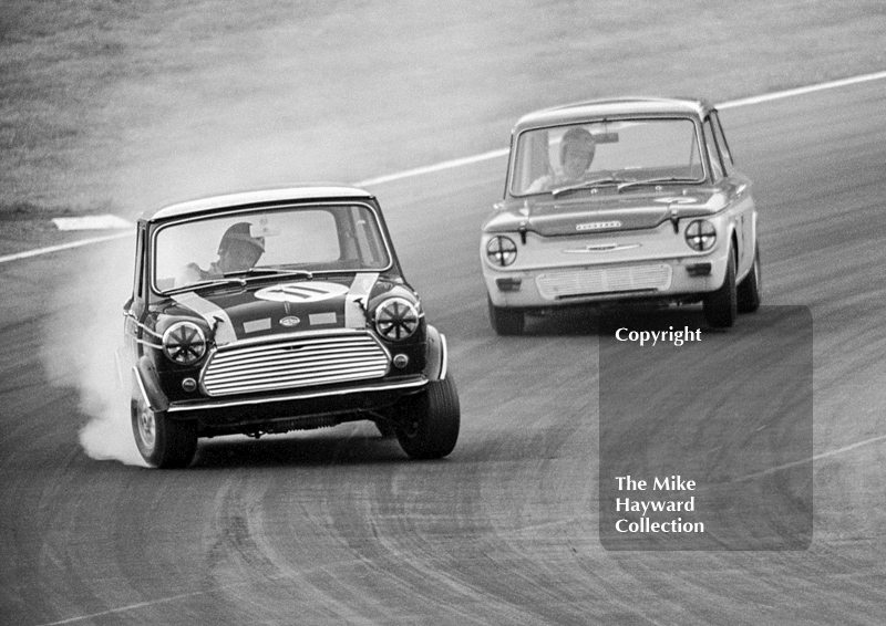 John Rhodes, Cooper Car Company Mini Cooper S, leads Tony Lanfranchi, Alan Fraser Sunbeam Imp,&nbsp;at South Bank Bend, Brands Hatch, Grand Prix meeting 1968.
