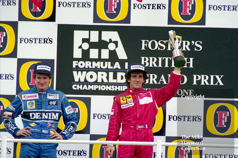 Thierry Boutsen and race winner Alain Prost on the podium at the 1990 British Grand Prix
