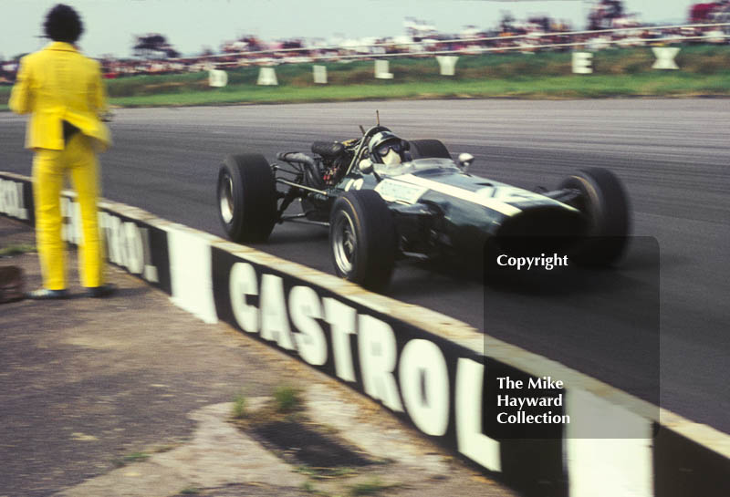 Pedro Rodriguez, Cooper Maserati V12 T81, passes a yellow-suited photographer at Copse Corner, Silverstone, 1967 British Grand Prix.
