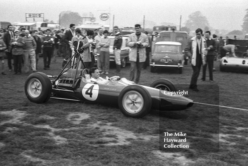 Jim Clark, Lotus 25, with film camera, Oulton Park Gold Cup 1963.
