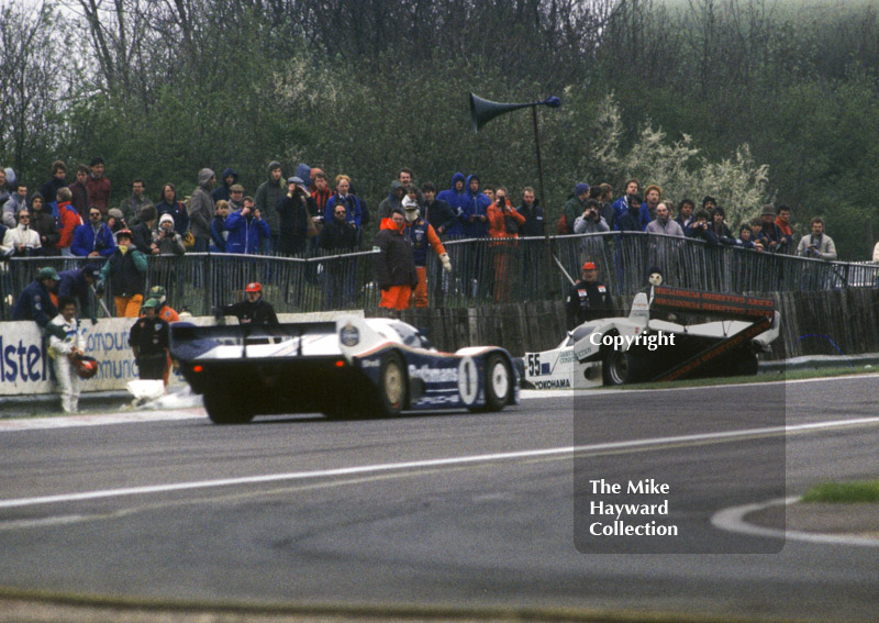 Winning Porsche 956 of Jochen Mass and Jacky Ickx passes a stricken car at Copse Corner, World Endurance Championship, 1985&nbsp;Grand Prix International 1000km meeting, Silverstone.
