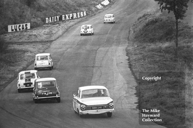 Lotus Cortina (95B UNK) chases a pack of minis (FTB 939B, Liz 1)Â up Clay Hill, Oulton Park, Gold Cup meeting 1964.