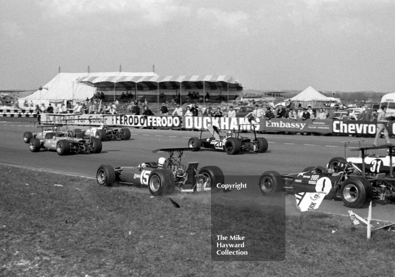 Clay Regazzoni, Ferrari Dino 166, smashes through a circuit marker board avoiding Graham Hill, with clutch trouble in his Roy Winkelmann Lotus 59B, Thruxton, Easter Monday 1969.
