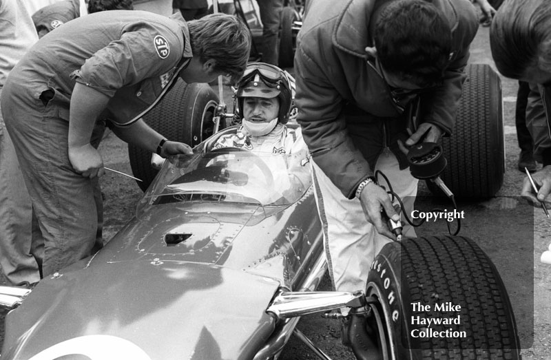 A technician checks the Firestone tyres on Graham Hill's Gold Leaf Team Lotus 49 during practice for the 1968 British Grand Prix at Brands Hatch.
