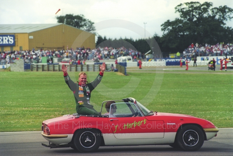 Johnny Herbert waves to the crowd at Silverstone for the 1993 British Grand Prix.
