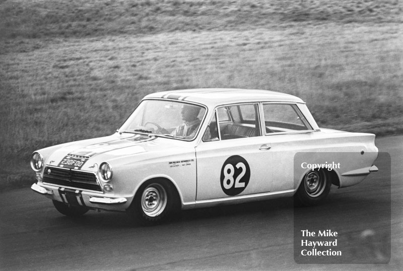 Bob Olthoff in a John Willment Lotus Cortina, 230 F00, at Nickerbrook, Oulton Park, Gold Cup meeting 1964.
