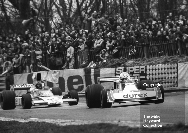 Alan Jones, Durex Surtees TS19, leads race winner James Hunt, Marlboro McLaren M23, out of Druids Hairpin at the Race of Champions, Brands Hatch, 1976.
