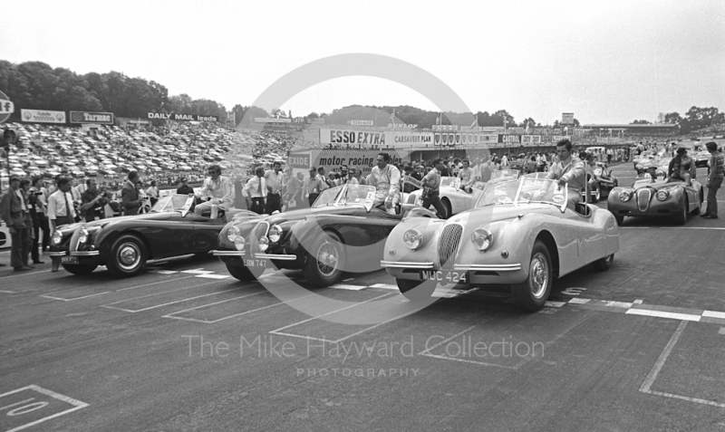 Drivers are paraded in Jaguar XK120 sports cars before the start of the 1970 British Grand Prix at Brands Hatch to commemorate the 21st anniversary of a Jaguar-powered race win. On the front row from left are Jochen Rindt, Jack Brabham and Jacky Ickx.
