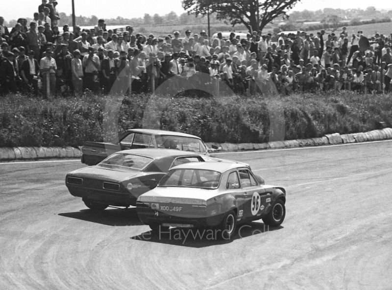 Dennis Leech, Ford Falcon Sprint, spins at Shaw's Hairpin, eliminating Roy Pierpoint, Chevrolet Camaro, and Frank Gardner, Alan Mann Ford Escort Twin Cam (XOO 349F), British Saloon Car Championship race, BRSCC Guards 4,000 Guineas International meeting, Mallory Park, 1969.
