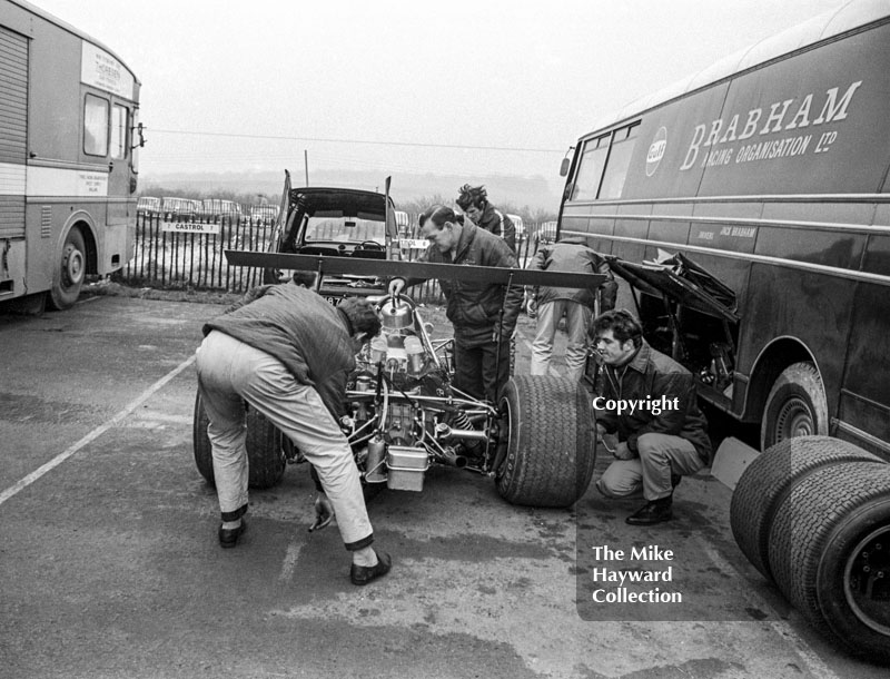 A Brabham BT26 being topped up with water from a kettle, Brands Hatch, 1969 Race of Champions.
