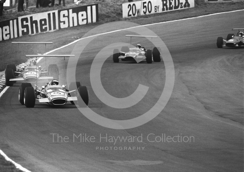 Jackie Oliver, Gold Leaf Team Lotus 49B trails oil smoke followed by team mate Graham Hill, winner Jo Siffert in a Rob Walker Lotus 49B, and Chris Amon, Ferrari V12, British Grand Prix, Brands Hatch, 1968

