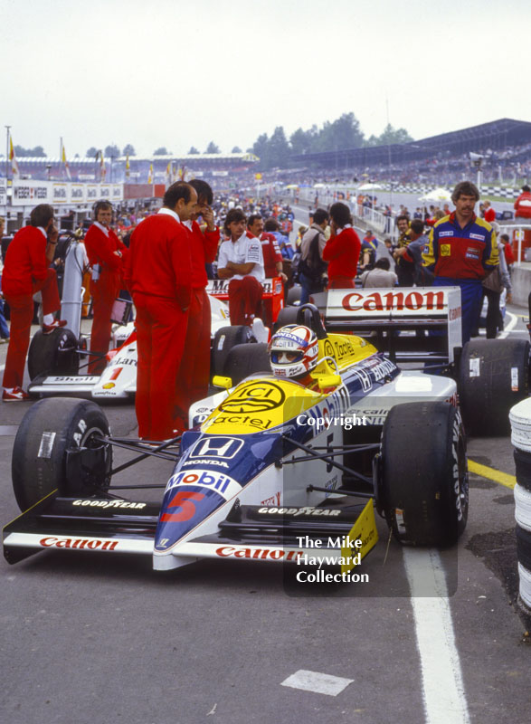 Nigel Mansell, Williams Honda FW11, surrounded by McLaren pit crew, Brands Hatch, 1986 British Grand Prix.
