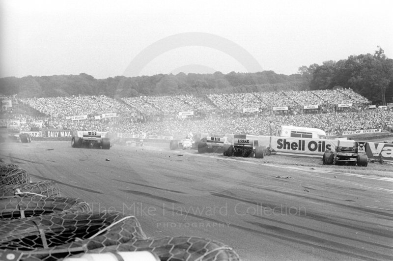 First corner accident with Jacques Laffite's Ligier JS27, hitting the barrier, right, Brands Hatch, British Grand Prix 1986.
