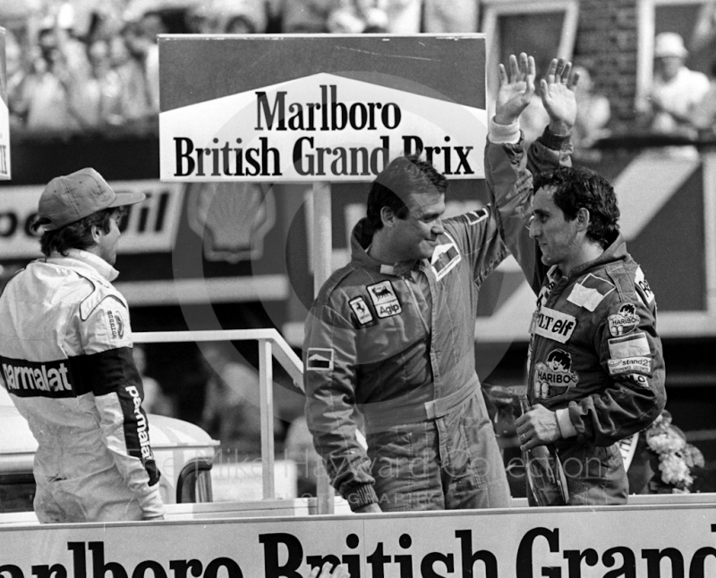 Alain Prost, Renault RE40, Patrick Tambay, Ferrari 126C3, and Nelson Piquet, Brabham BT52B, on the podium, British Grand Prix, Silverstone, 1983
