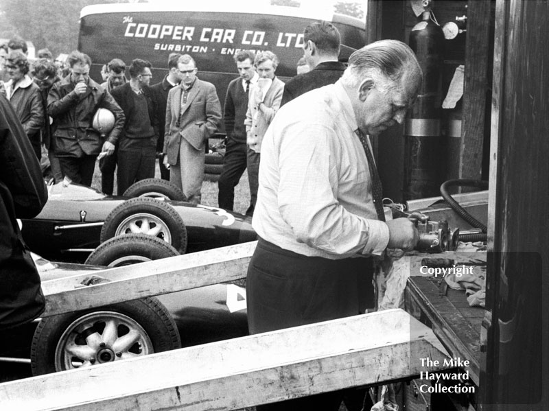 Reg Parnell at work on a Lola carburettor in the paddock, Oulton Park Gold Cup 1962.
