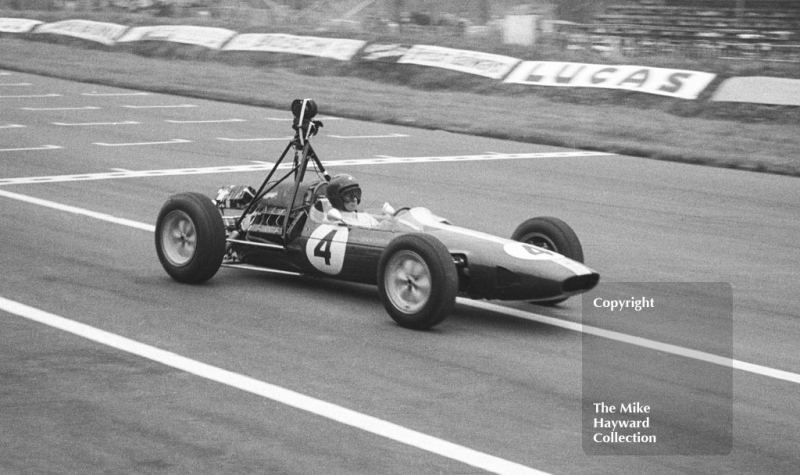 Jim Clark, Lotus 25, with film camera, Oulton Park Gold Cup 1963.
