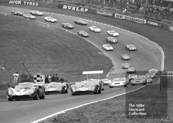 John Surtees/David Hobbs, Lola T70 Mk3, lead on the first lap, followed by Jonathan Williams/Paul Hawkins, Ferrari 330P4, and Ludovico Scarfiotti/Peter Sutcliffe, Ferrari 330P4, Brands Hatch, BOAC 500 1967.
