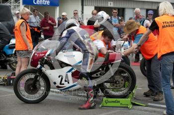 A Triumph classic bike gets a last-minute check in the paddock, Silverstone Classic, 2010