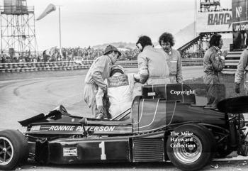 Marshals help Ronnie Peterson out of his Project Three Racing March 752 BMW M12 after the chicane accident, Wella European Formula Two Championship, Thruxton, 1975
