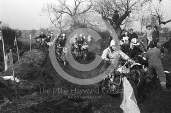 Scrambling through mud, motorcycle scramble at Spout Farm, Malinslee, Telford, Shropshire between 1962-1965