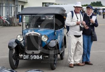 Elderly couple next to an RAC Austin Seven car in the paddock, Silverstone Classic 2010
