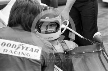 Carlos Reutemann, Brabham, chats to a mechanic on the grid before the start of the 1974 British Grand Prix at Brands Hatch.
