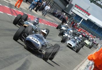 HGPCA pre-1966 GP cars led in the pit lane by Sidney Hoole, Cooper T66, and Roy Walzer, 1964 Brabham BT11, Silverstone Classic, 2010