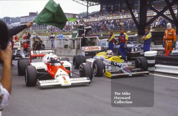 Alain Prost, McLaren MP4, and Nigel Mansell, Williams Honda FW11, wait at the end of the pit lane to get on to the track, Brands Hatch, 1986 British Grand Prix.
