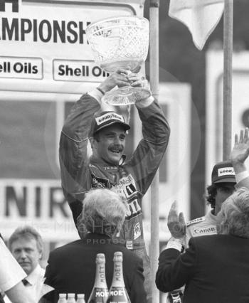 Nigel Mansell, Williams Honda, holds aloft the winner's trophy, Brands Hatch, British Grand Prix 1986.
