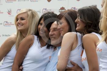 Sir Stirling Moss with a line-up of BSM girls, Silverstone Classic 2010