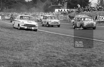 Jack Sears, Lotus Cortina (JTW 496C), takes to the grass with Michael Campbell-Cole and P Middlehurst (RDJ 167) in Mini Cooper S's alongside, Oulton Park Spring Race Meeting, 1965
