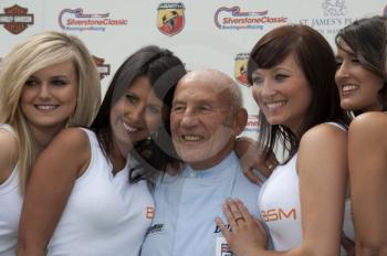 Sir Stirling Moss with a line-up of BSM girls, Silverstone Classic 2010