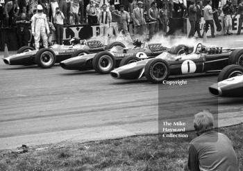 Jim Clark and Graham Hill, Lotus Cosworth 49s, and Jack Brabham, Repco Brabham BT24 V8, leave the grid at Silverstone, 1967 British Grand Prix.
