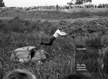 Alan Hutcheson jumps to dry land from the roof of his Riley 1.5, Oulton Park, Gold Cup meeting 1962.
