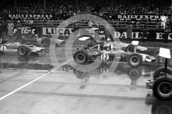 Jo Siffert, Rob Walker Lotus 49B, leaves the grid with Bruce McLaren, McLaren Ford M7C, and Graham Hill, Gold Leaf Team Lotus 49B, Silverstone, International Trophy 1969.
